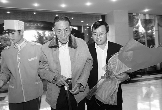 2008年10月12日，云南省腾冲县当地群众搀扶着李锡全老人，迎接他返回祖国。