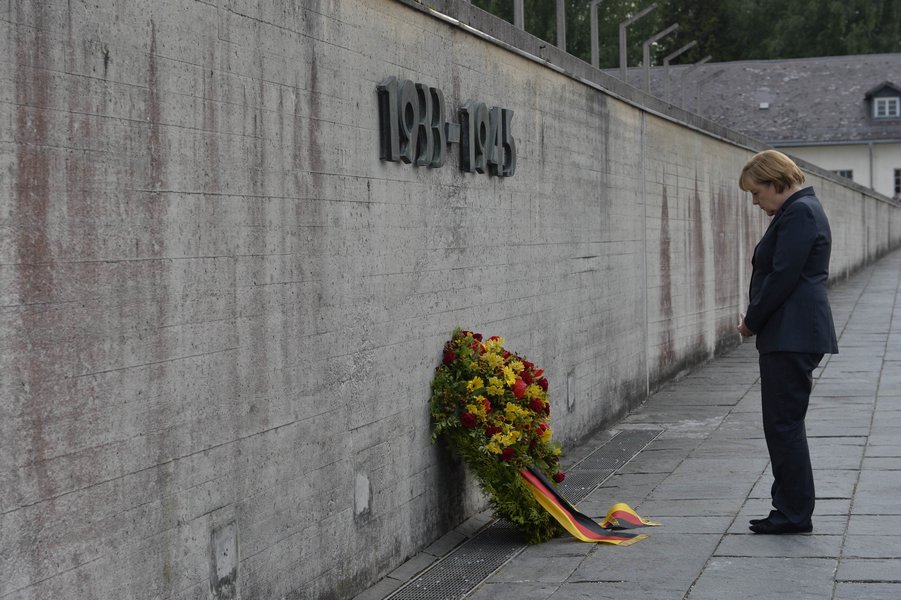 2013年8月20日，德国总理默克尔在达豪纳粹集中营纪念馆默哀。这是在职德国政府首脑首次访问达豪集中营纪念馆。
