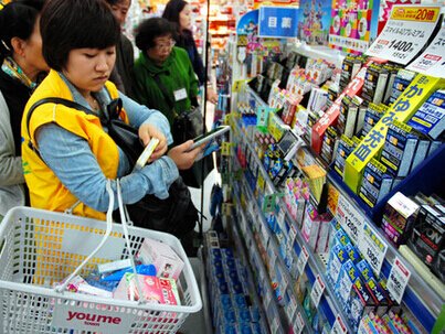 中国游客比对智能手机里的照片在日购物