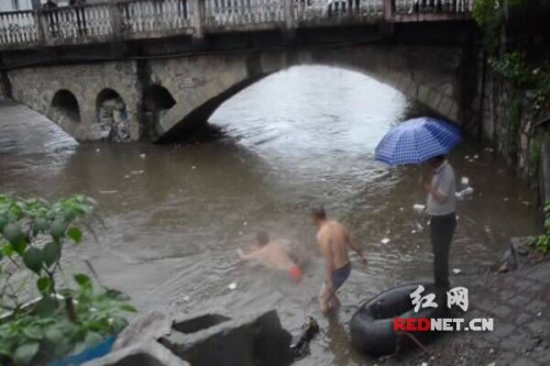 湖南一男子因暴雨被困桥洞当地镇长跳河救人（图）