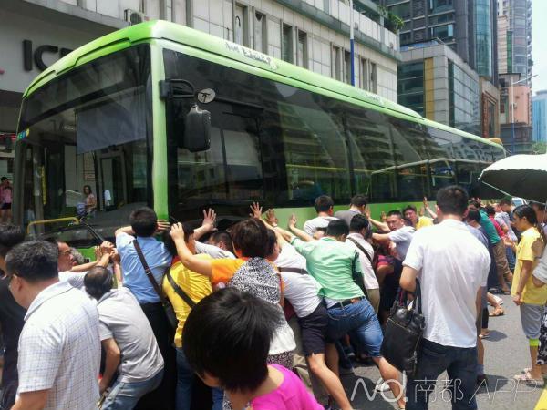 广州一老太太被卷入车底 数十人合力抬车