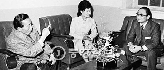 1976年某日晚上，时任总统朴正熙视察大韩救国宣教团的夜间诊疗中心，与宣教团总裁崔泰敏（音，右）交谈。中间一位为当时担任宣教团名誉总裁的朴槿惠。（照片来源：中央图片）