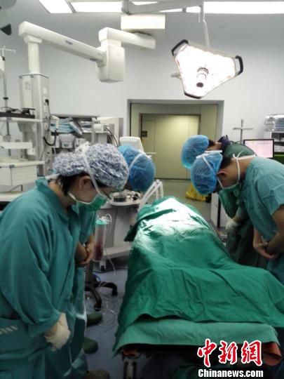 李智博器官摘除手术结束后，医护人员向遗体默哀致敬。　王秋红 摄