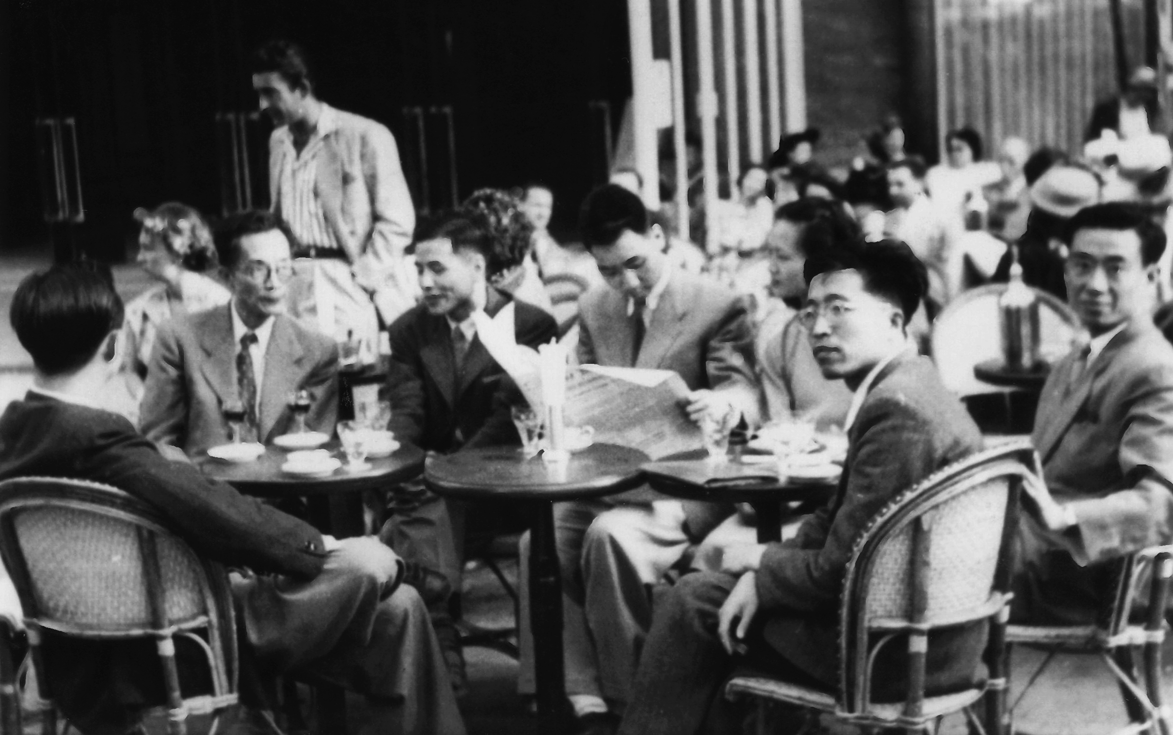 1949年，许渊冲（左四）与留法校友在法国香榭丽舍林荫大道露天咖啡馆欢迎梅贻琦（左二）