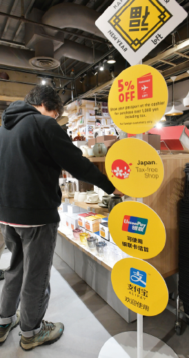 左图：2017年1月，日本东京涩谷的一家购物店，店内竖立着可以使用支付宝和银联的标志牌。