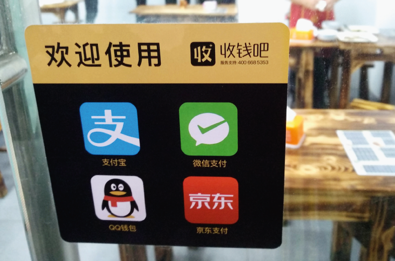 右图：2017年12月，福州一家餐饮店张贴着多个电子支付标识。