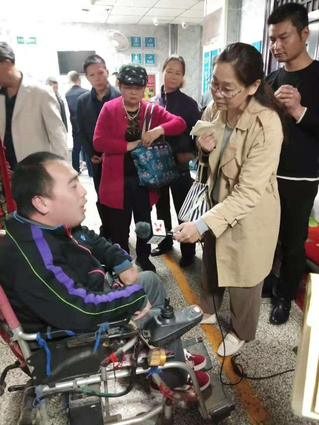 昔日残疾受助者王六勇坐着轮椅帮英雄
