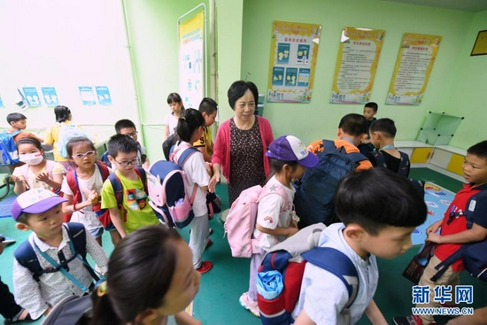 林丹来到军门社区“阳光朵朵”少儿托管中心看望放学后在这里托管的小朋友（6月23日摄）。新华社记者 林善传 摄