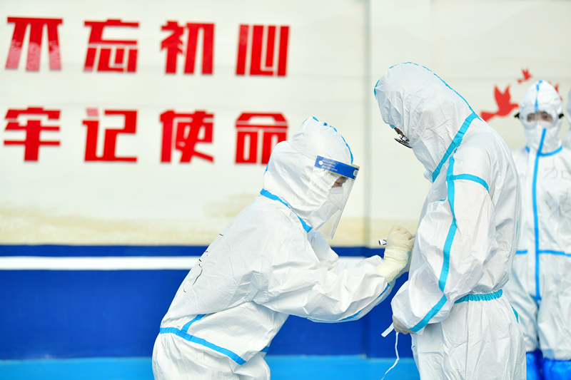 2020年7月1日，北京一街道开展新冠肺炎核酸检测工作。医护人员上岗前穿好防护服后在衣服上写上名字和激励打气的词语。