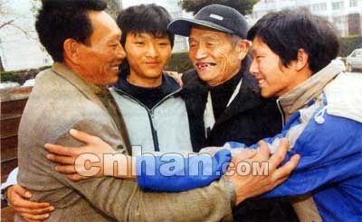 2006年1月16日，四川渠县，团圆的蒋川父子与宋大爷拥抱在一起。（翻拍）